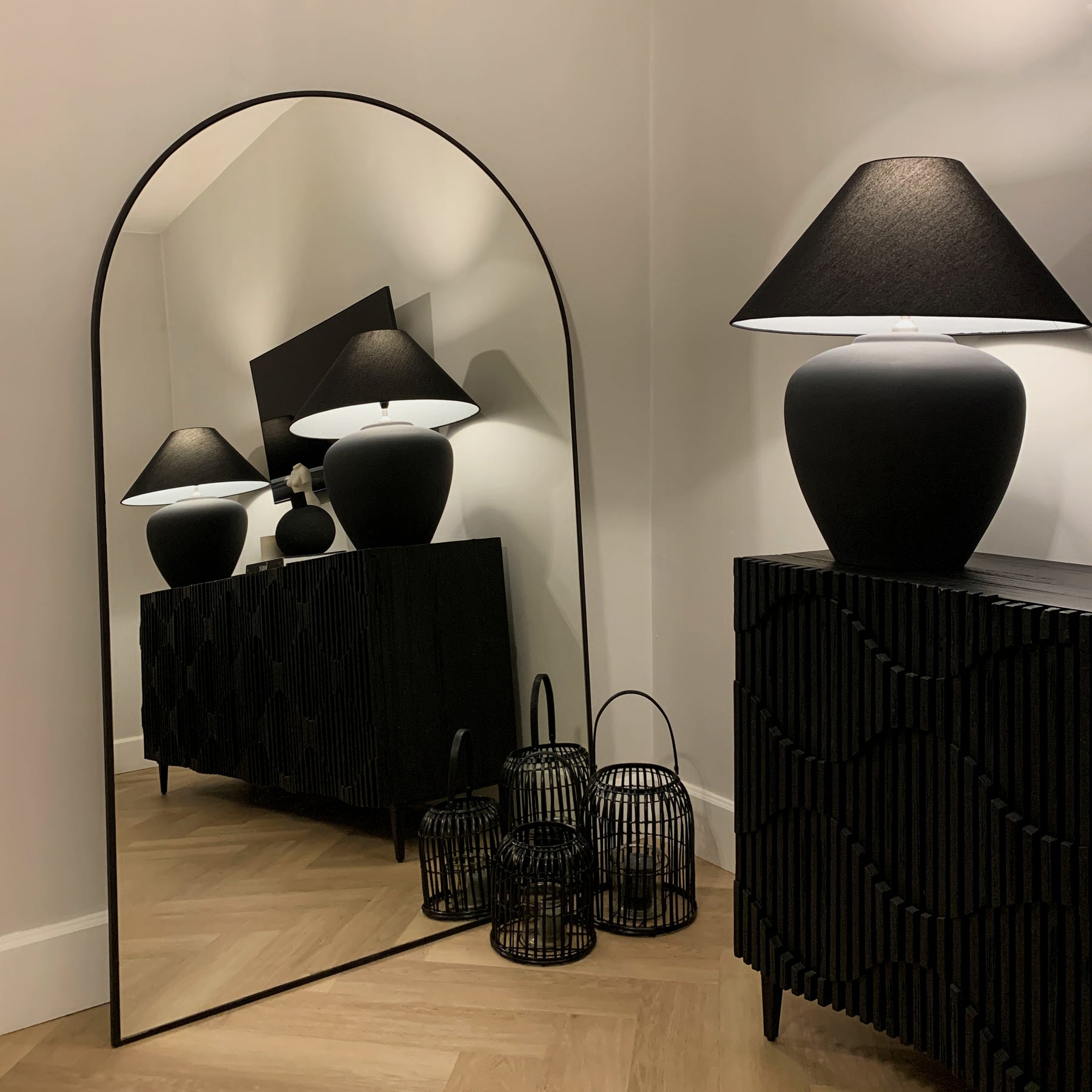 Black Full Length Arched Metal Mirror beside lamp