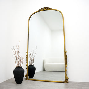 Full Length Gold Arched Ornate Metal Mirror beside vase