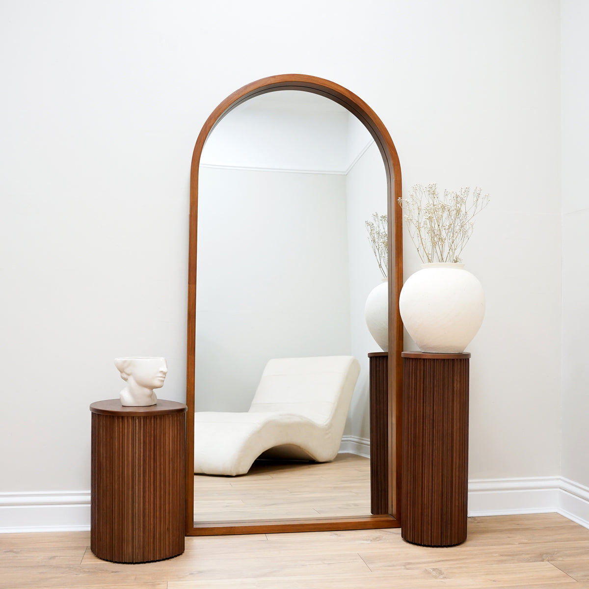 Walnut Organic Full Length Wooden Arched Mirror between two pedestals