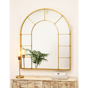 Gold industrial arched full length metal mirror on wall