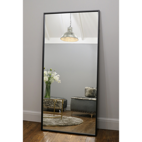 Full Length Black Industrial Metal Mirror reflecting light in living room