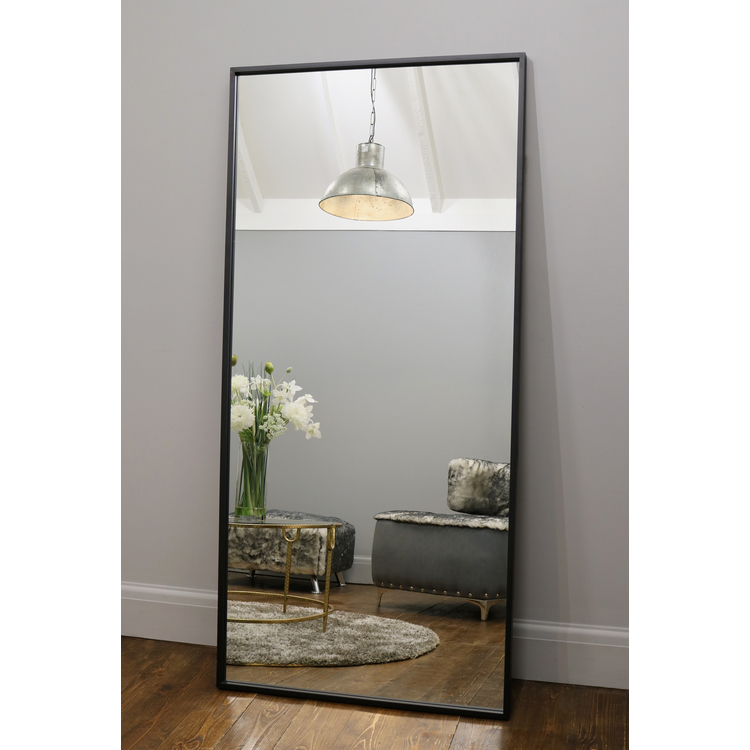 Full Length Black Industrial Metal Mirror reflecting light in living room