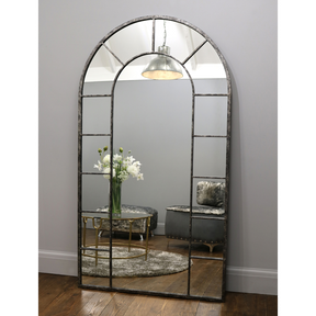 Crushed black industrial arched full length metal mirror with lounge in reflection