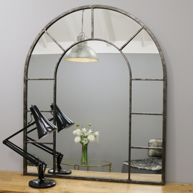 Crushed black industrial arched metal wall mirror with desk lamp
