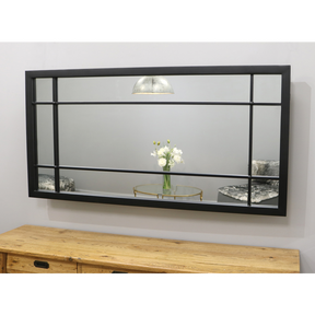 Black industrial metal console mirror displayed above console table