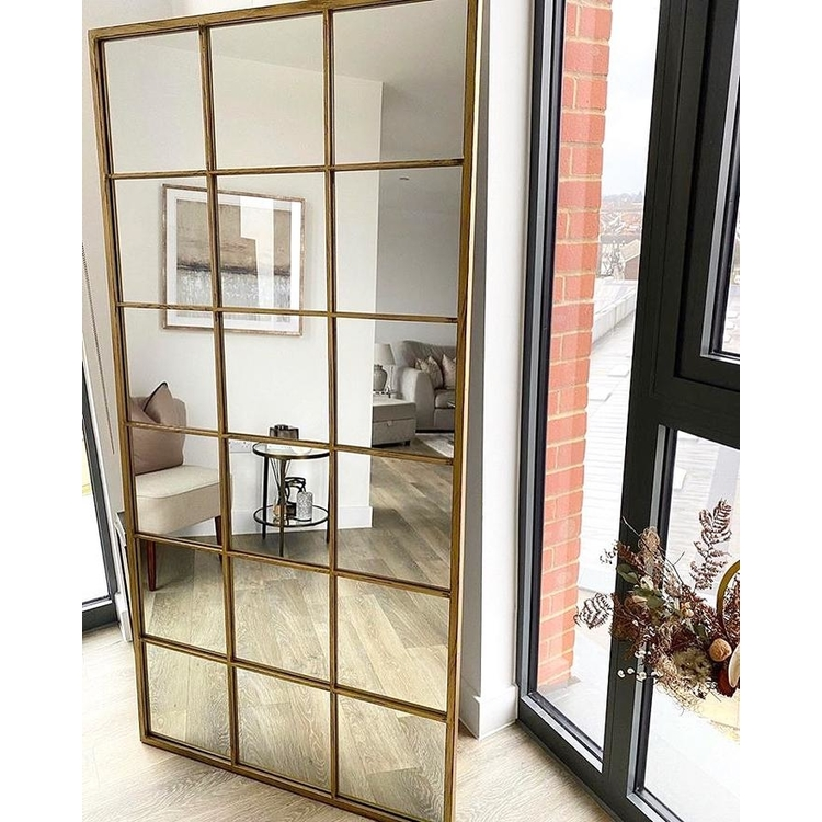 Full length large gold industrial metal window mirror leaning against wall