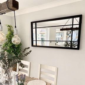 Black industrial metal console mirror displayed in dining room