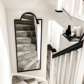 Full length black industrial arched metal mirror as wall mirror on staircase