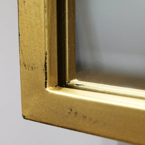 Detail shot of Large gold industrial metal window mirror corner