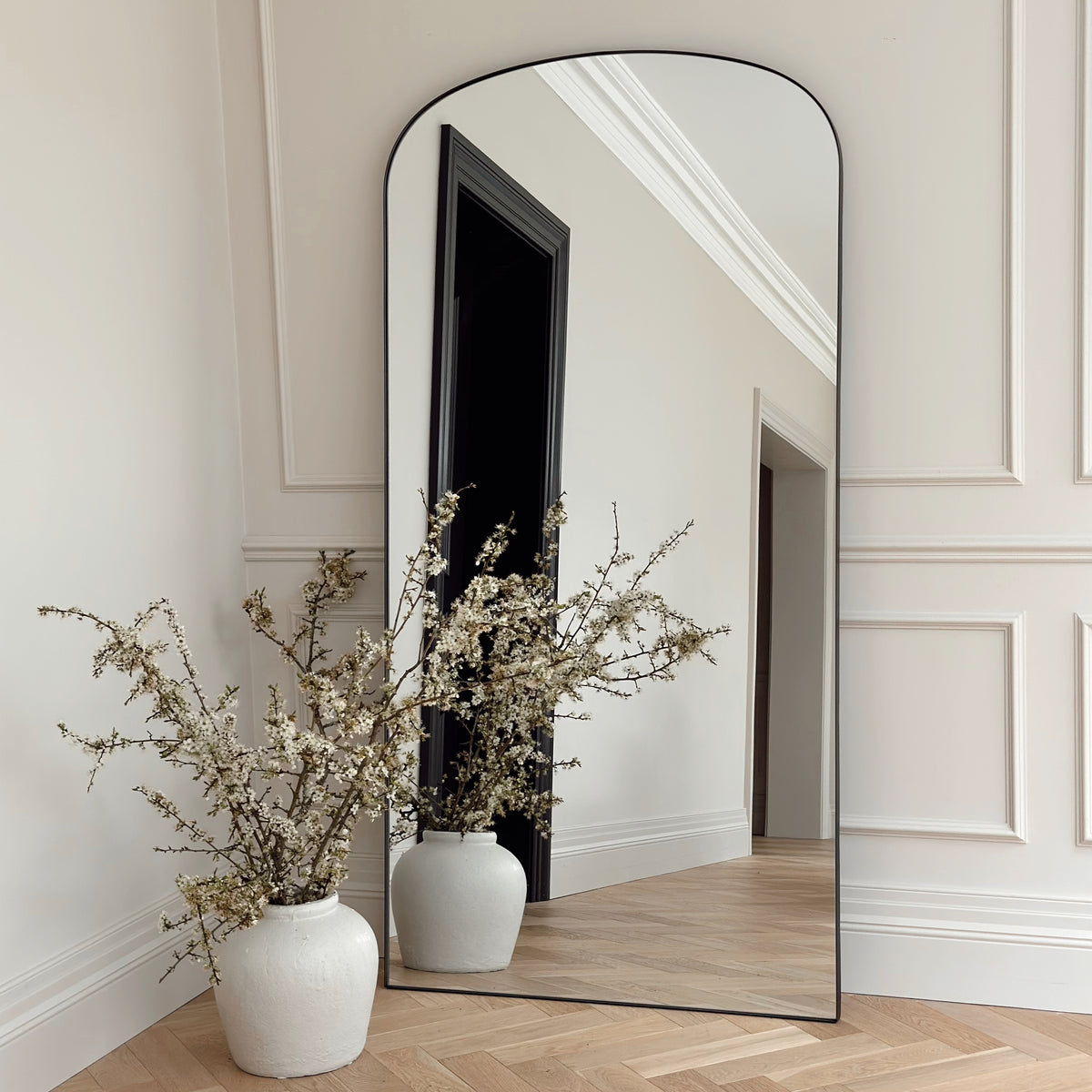 Full length black large metal mirror leaning against wall