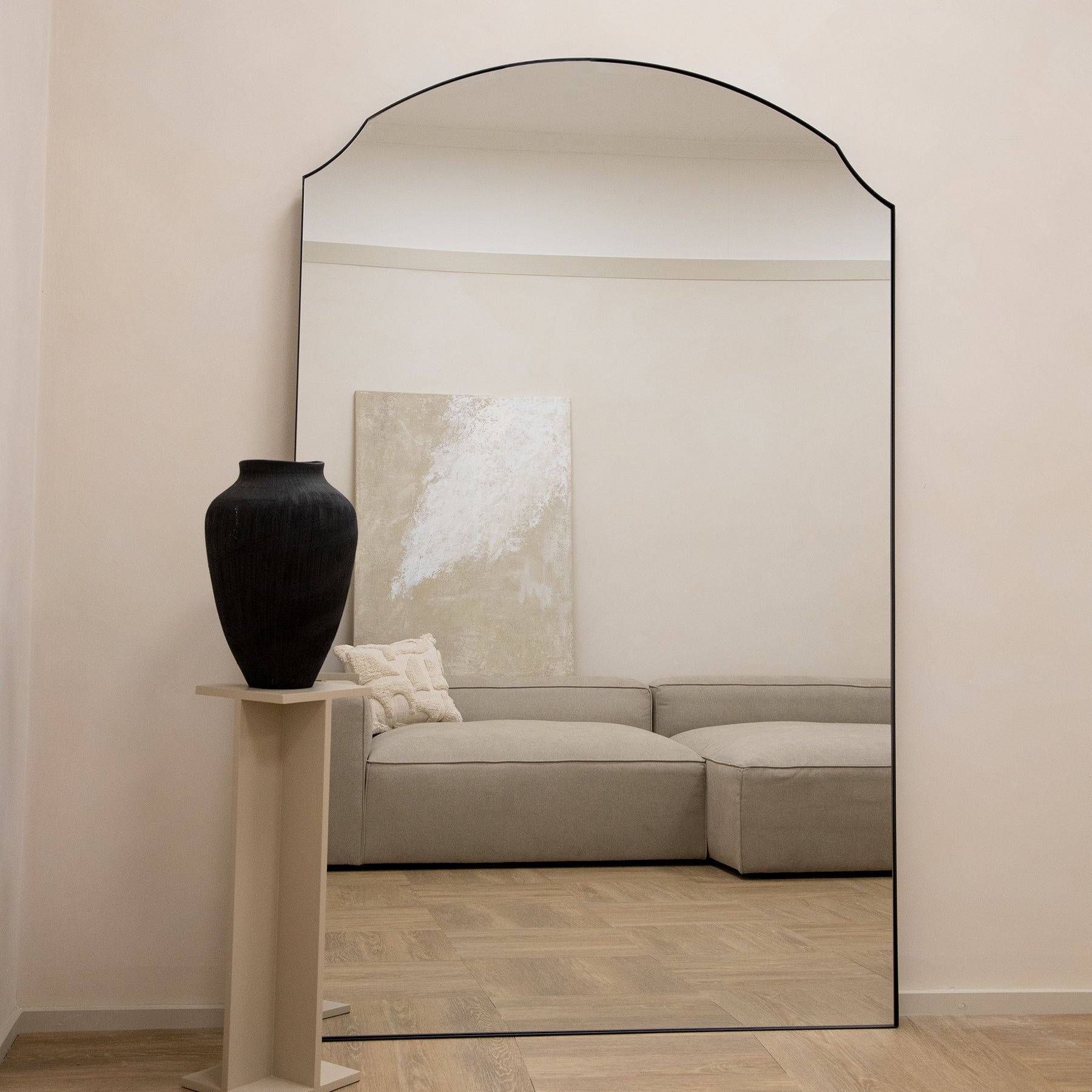 Black Full Length Arched Metal Mirror as a lean to beside ceramic vase