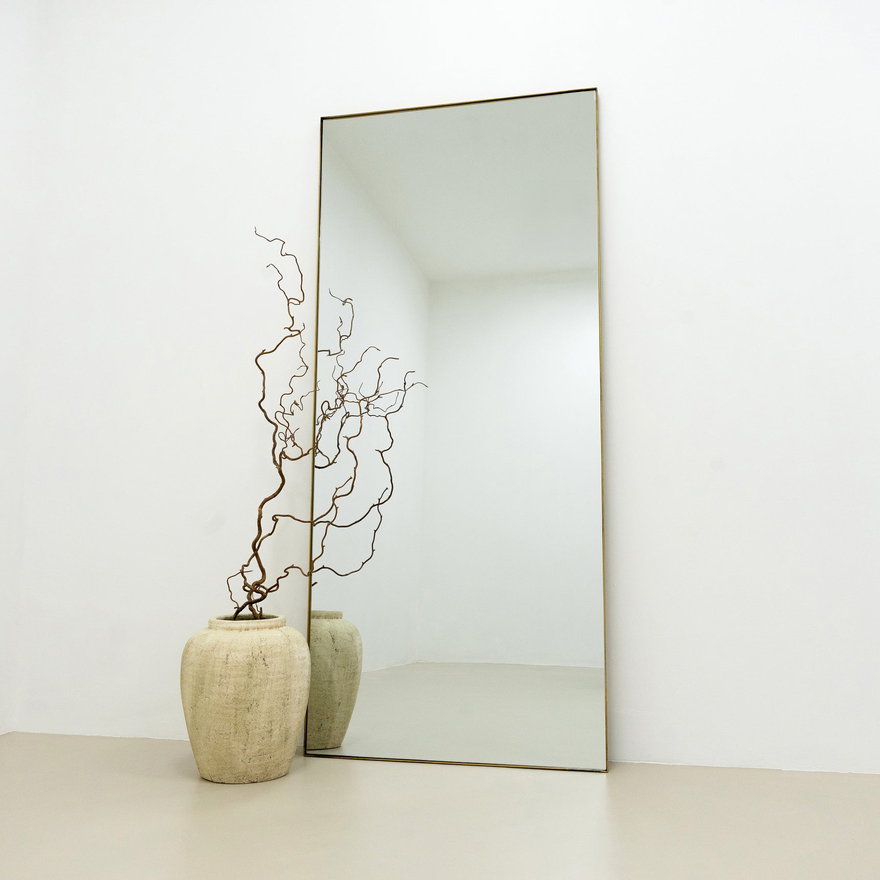 Full Length Gold Rectangular Large Metal Mirror beside vase