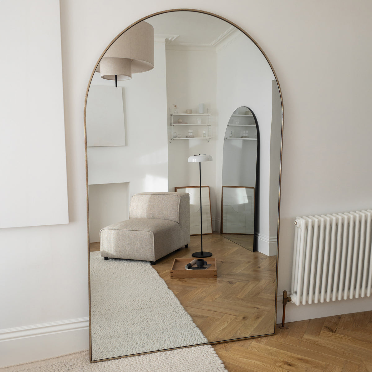 Champagne Full Length Arched Metal Mirror in living room leaning against wall