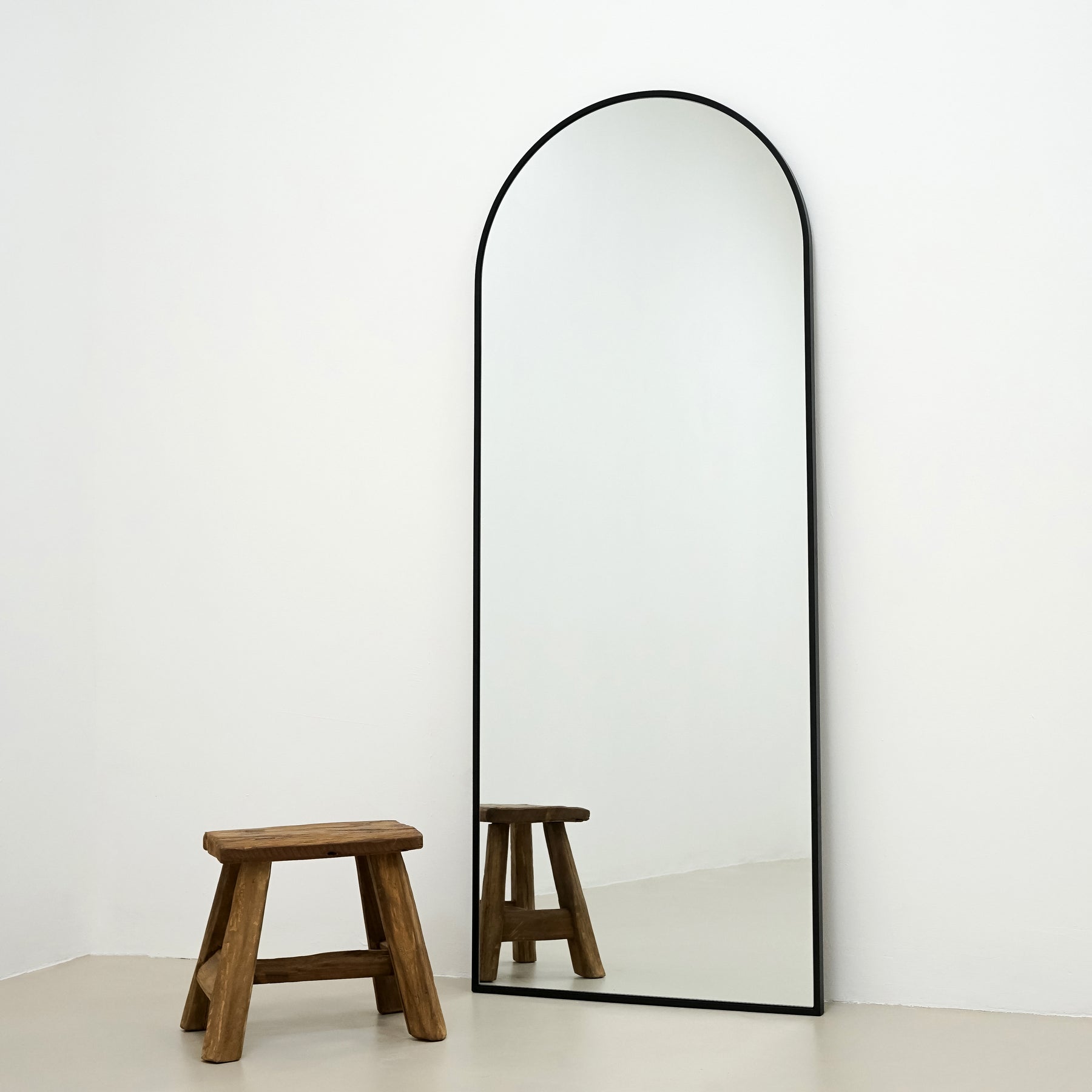 Champagne Full Length Arched Metal Mirror beside stool