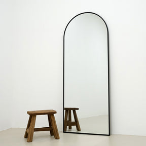 Champagne Full Length Arched Metal Mirror beside stool