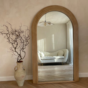 Full Length Arched Washed Wood Mirror leaning against wall in lounge