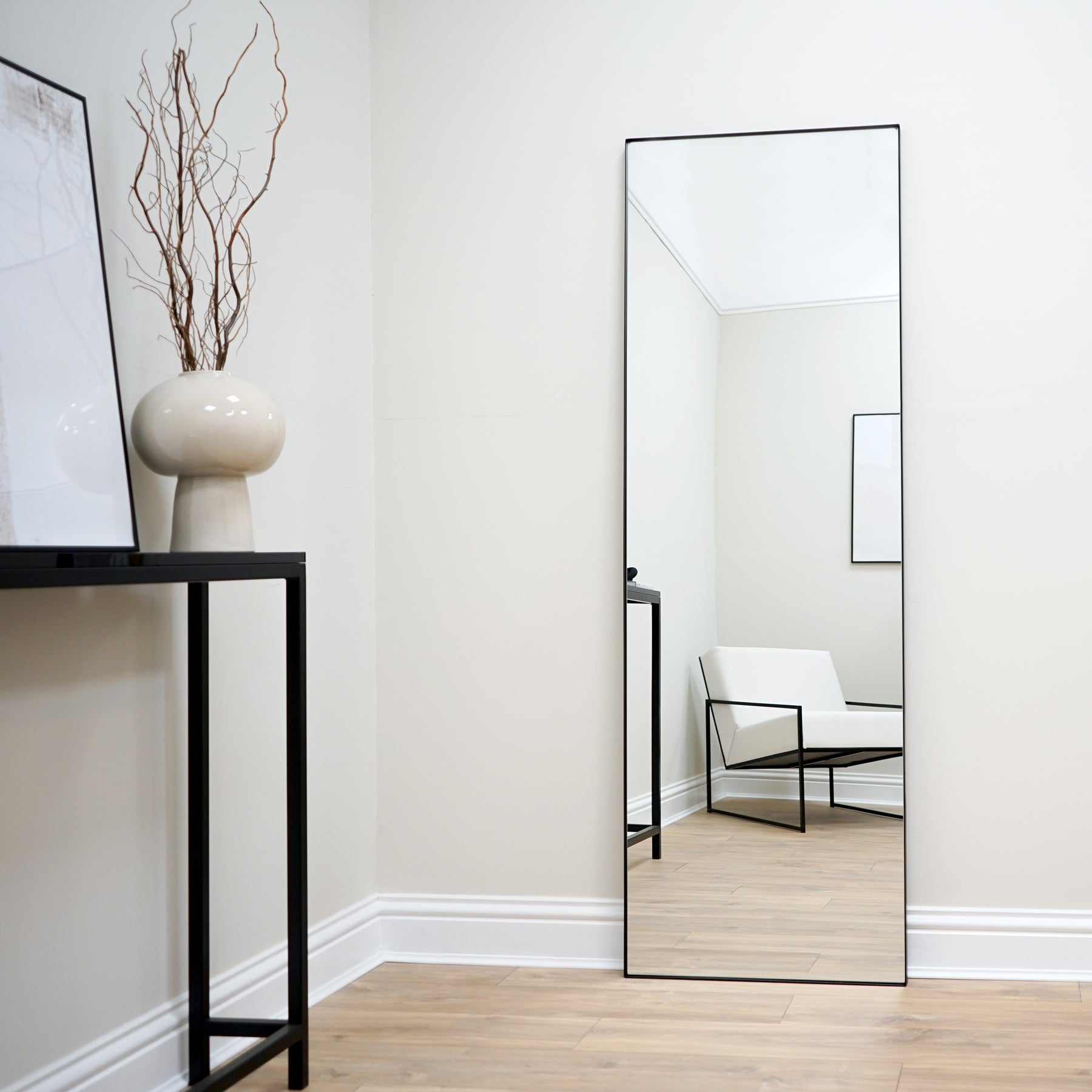 Full Length Black Rectangular Large Metal Mirror reflecting lounge chair