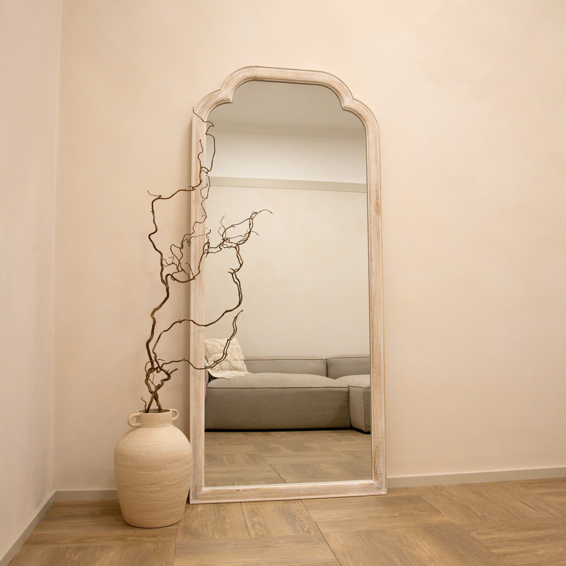 Full Length White Washed Wood Arched Mirror beside ceramic vase