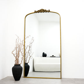 Extra large gold vintage arched metal mirror leaning against wall