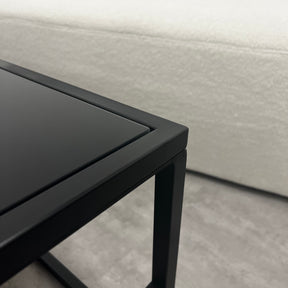 Closeup of Black modern large rectangle tinted mirrored coffee table corner