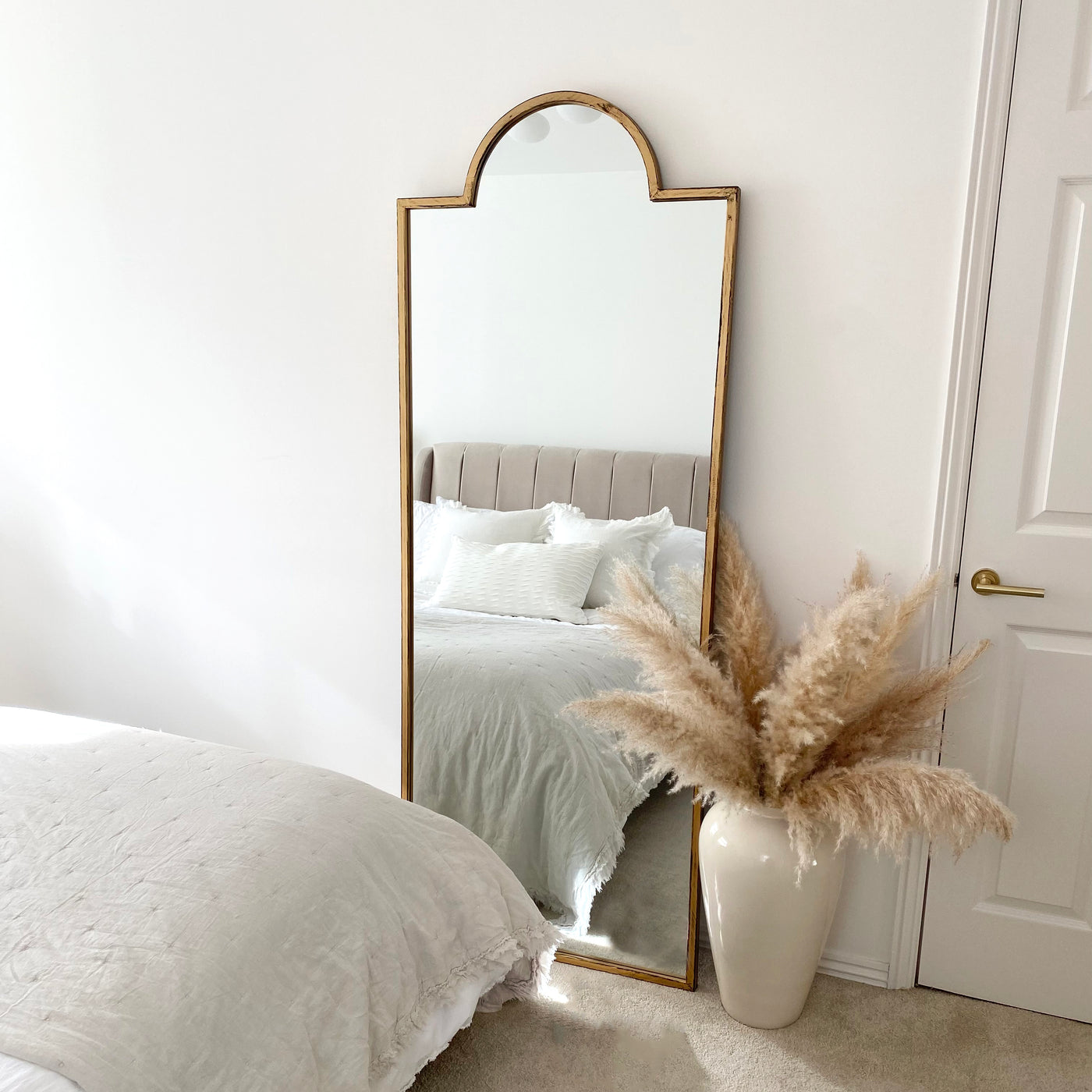 Full length gold industrial arched metal mirror in bedroom