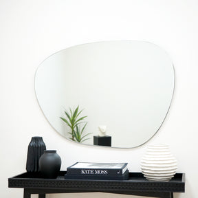 Large Frameless Pond Mirror on wall above ceramics and books