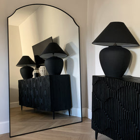 Black Full Length Arched Metal Mirror beside lamps