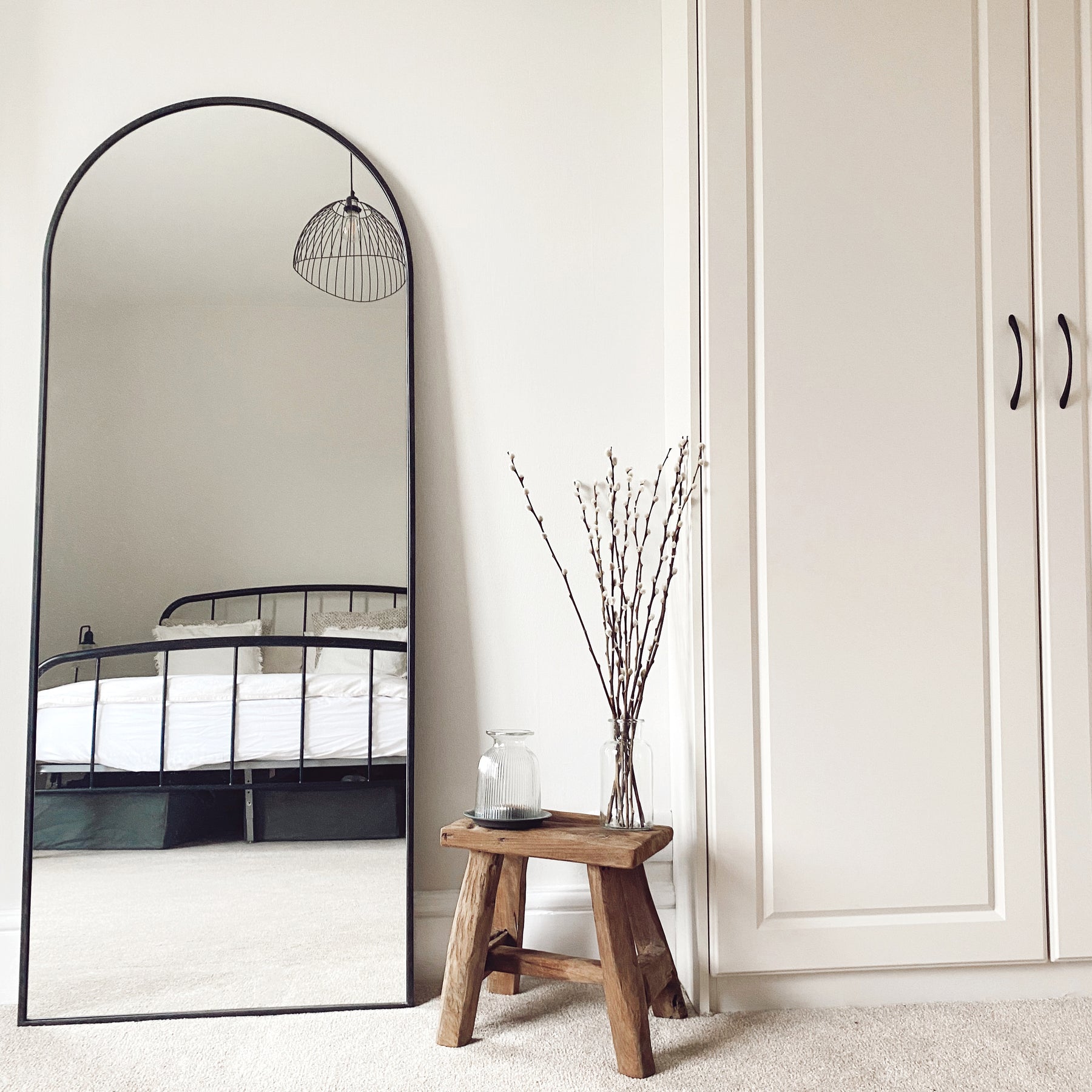 Champagne Full Length Arched Metal Mirror in bedroom beside bench