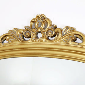 A detail of this mirrors ornate frame moulding.