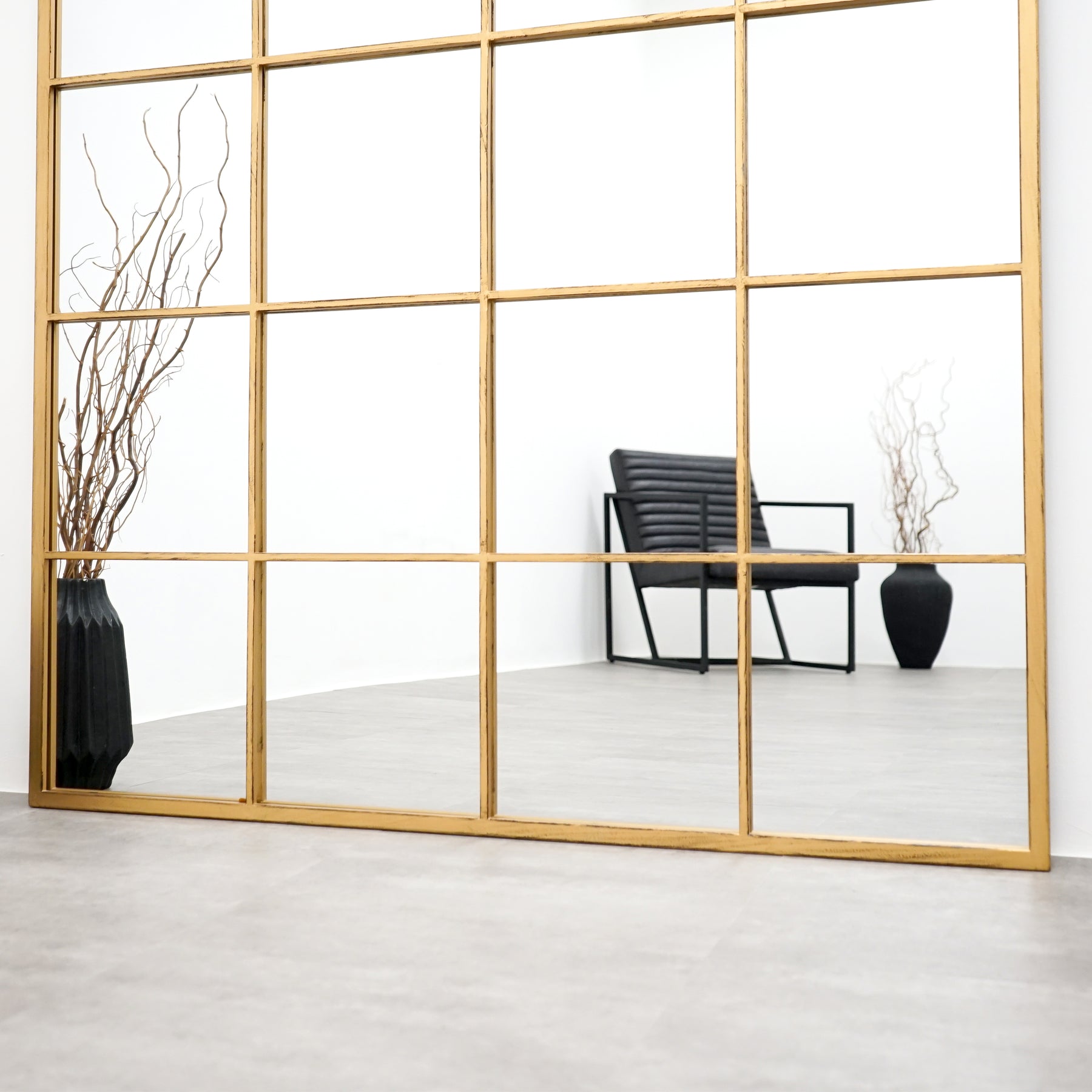 Full length extra large gold industrial metal window mirror with chair in reflection