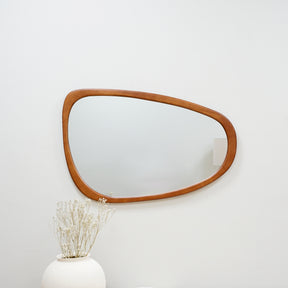 Organic irregular walnut-coloured wooden wall mirror displayed horizontally