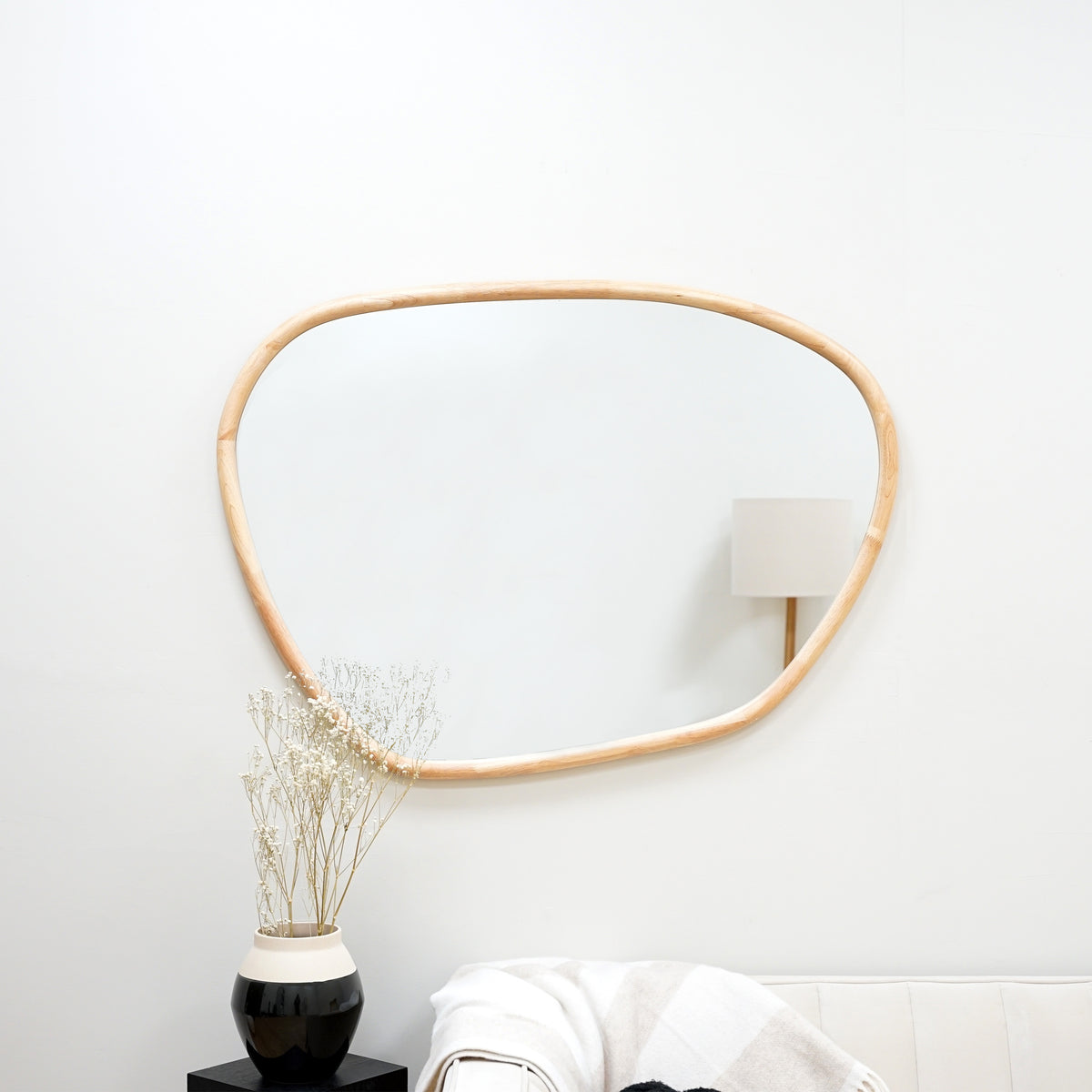 Organic irregular natural-coloured wooden wall mirror displayed horizontally